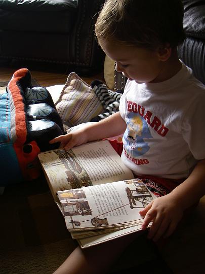 IMGP5479.JPG - Sammy is reading his "Engines" book (from the 1950's and meant for an 8th grader) to his "friends" before their naptime. Then he did prayers and sang them the mayonnaise song and tucked them in. So cute! I have a movie of all this but it's like 400 MB since it's so long. I will burn to DVD and send to the grandparents :)