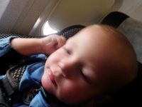 PB120019  Ben putting an earplug in, then he decided to chew it to see how it tasted. He thinks it's very funny to pick crumbs out of the back of his seat and pretend to eat them. GROSS! I pull his hand out of his mouth and he just cracks up!