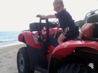 IMAG0341  The lifeguard's ATV is also of great interest every time we go by, so this day we decided to go ask if we could check it out. They said he could sit on it, too! The one lifeguard told me a funny story about how he ran into a tree one day because he was looking down at the ocean while riding along the ridgeline of dunes. Poor guy must have felt really dumb! He bashed up his nose and lip pretty good!