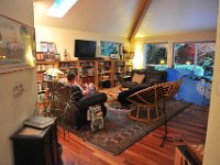 RMT 2114  Dave playing uke after dinner. The dog house is set up for the boys to play in. Past the big sliding doors is the deck, and then further out would be the driveway entrance.