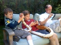 Pic-06022013-005  Sunday afternoon cubing and snake talking. I taught Ben about symmetry - one snake is more symmetrical than the other. The python (in Sam's lap) appears to be smiling on one side of his face but not the other. Dave is testing how to send pictures to my mom with his iPad.
