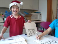 20141212 104124  Ben in our math pull-out enrichment group. He's showing how to create a table with headers and columns so you can more easily detect a pattern. Each of the four kids got a chance to "present" their work. Ben LOVES to wear a Christmas elf hat. He is the spirit of Christmas indeed!