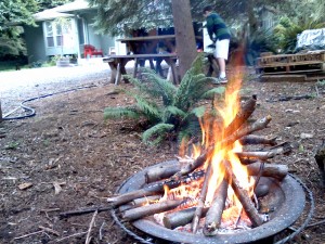 Friday fires! Sam cleaning pine needles off the picnic table for pizza with our neighbors.